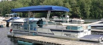 An older Harris pontoon boat with a 50 hp engine.